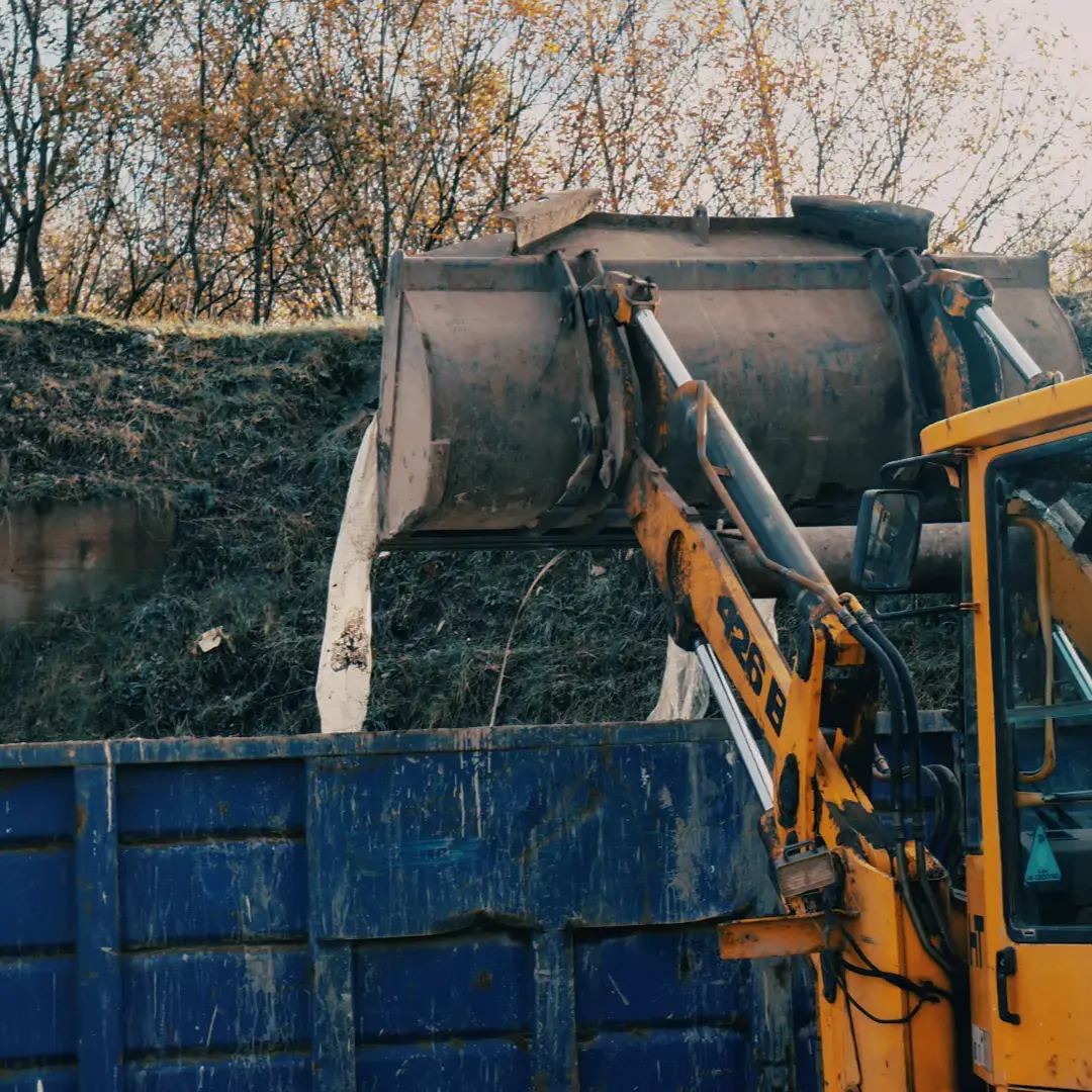 Ash Skip Hire loader truck in Northwich, skilfully depositing waste into a larger skip, exemplifying the company's efficient waste handling and management process.